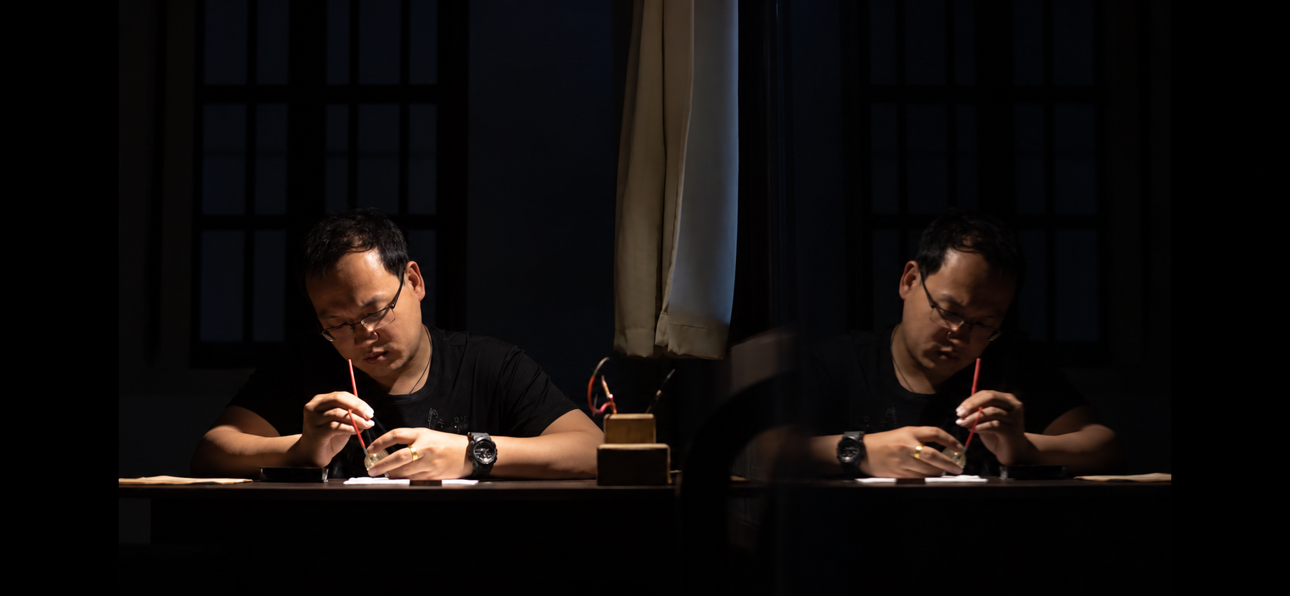 Master Lai Sijia painting beside his reflection